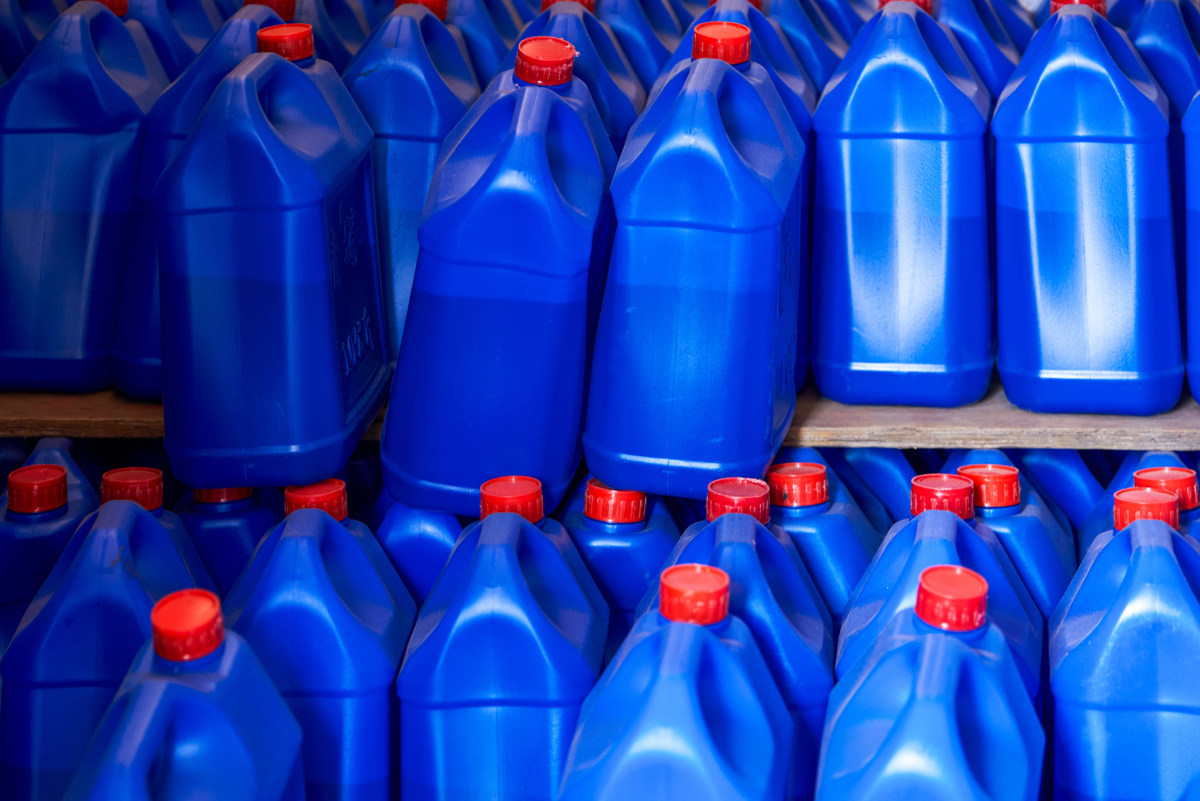 Closeup Of Blue Red Lid Plastic Oil Drums In Warehouse