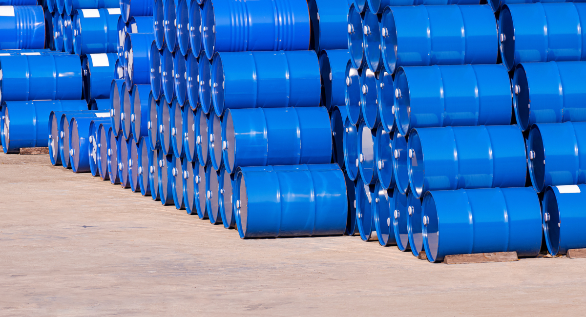 Piles Of Many Blue Oil Drums Stacked On Industrial Yard Area In Perspective Side View